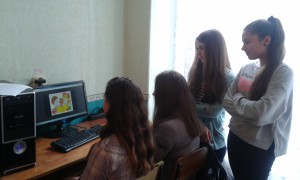 Trójka uczniów siedzi przed komputerem